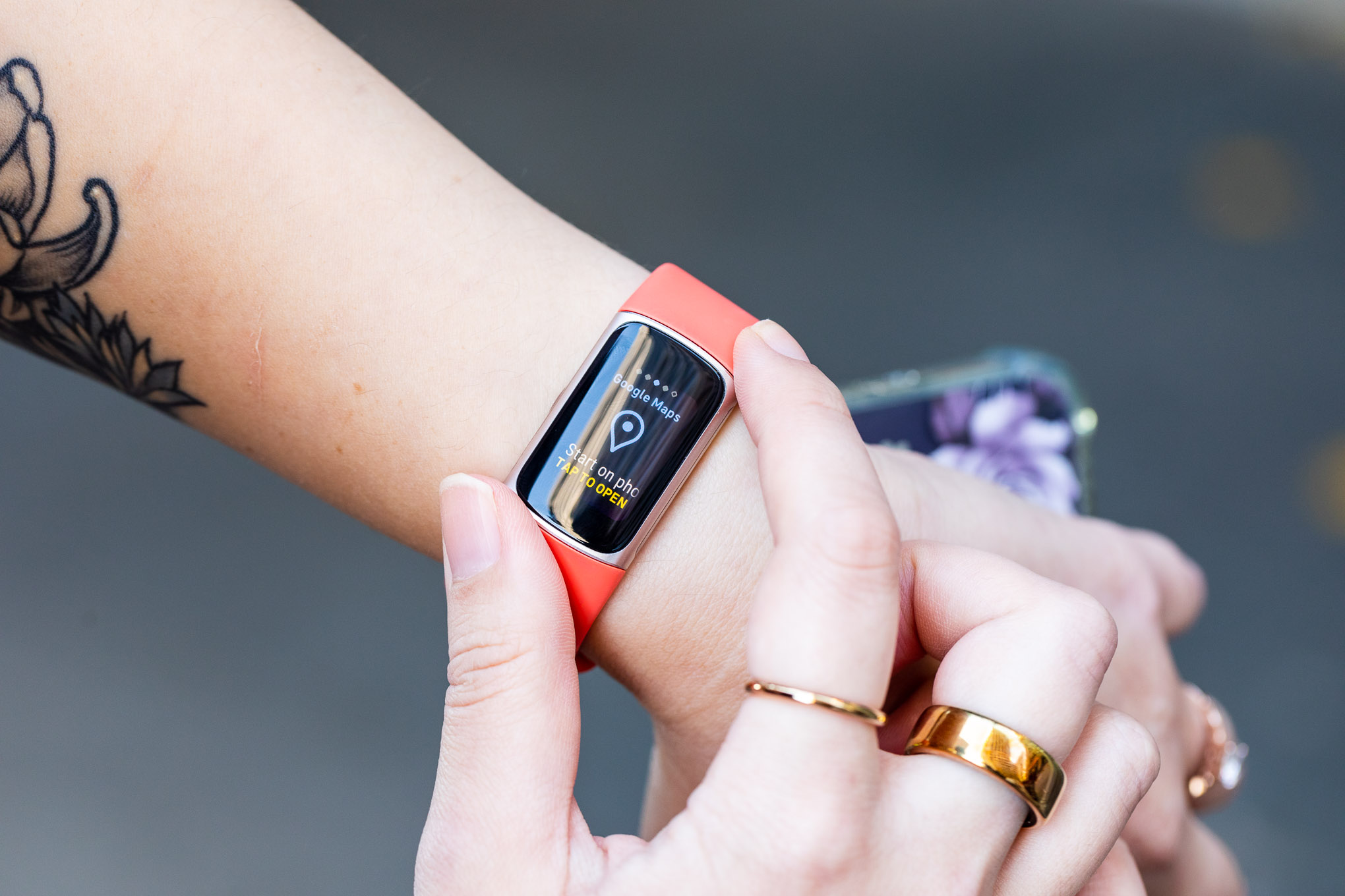 Людина, що дивиться на екран Google Maps на Fitbit Charge 6.