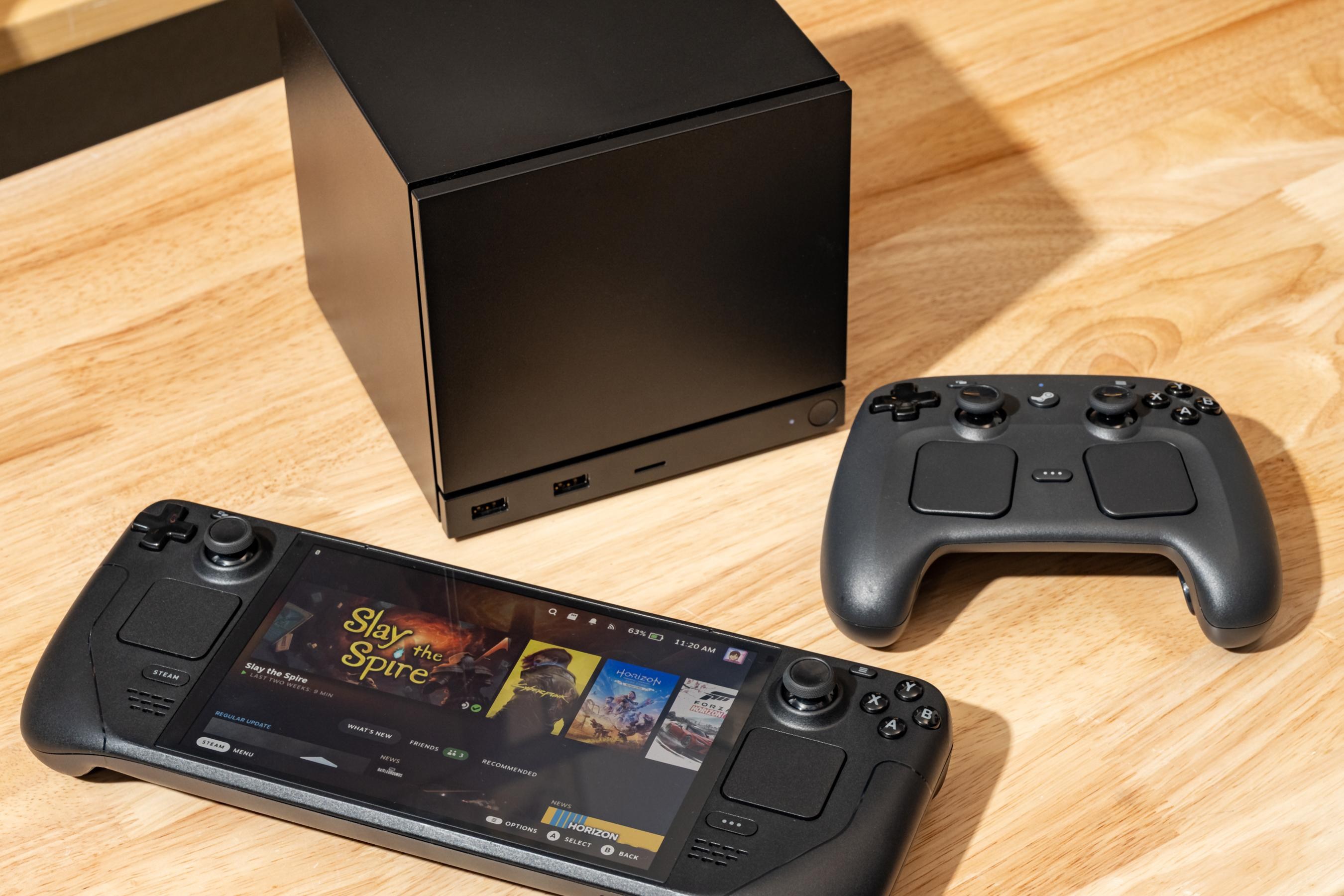 The Steam Machine, Steam Controller, and Steam Deck on a table.